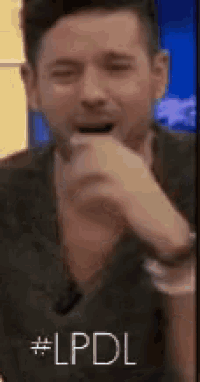 a man in a suit is covering his mouth with his hands and says # lpdl .