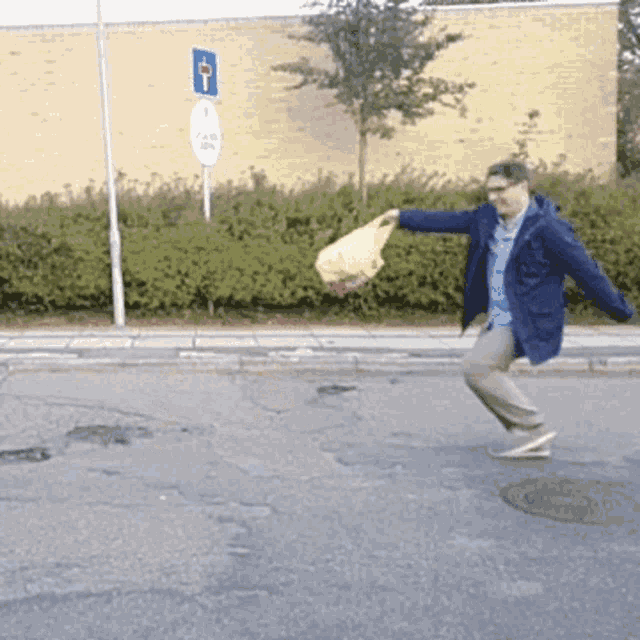 a man in a blue jacket is holding a yellow bag in his hand