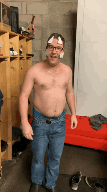 a shirtless man with a bandage on his forehead