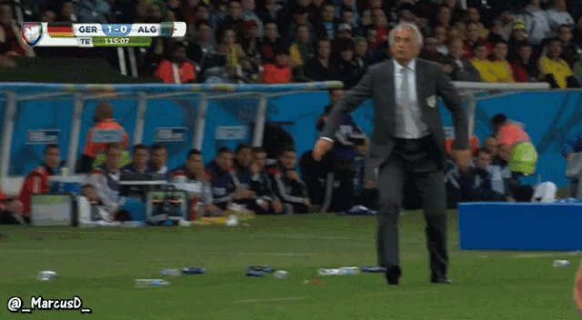 a man in a suit kicks a soccer ball during a game between ger and alg