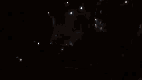 a blurred image of a person in a dark room with a light shining on them