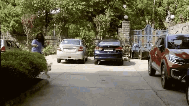 a row of cars are parked in a driveway in front of a house