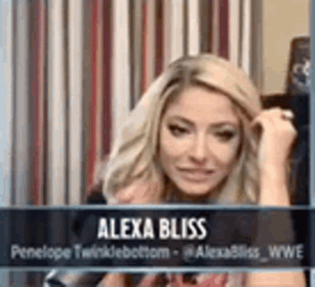 alexa bliss is sitting in front of a curtain and looking at the camera .