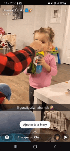 a little girl drinking from a gatorade bottle on a phone screen