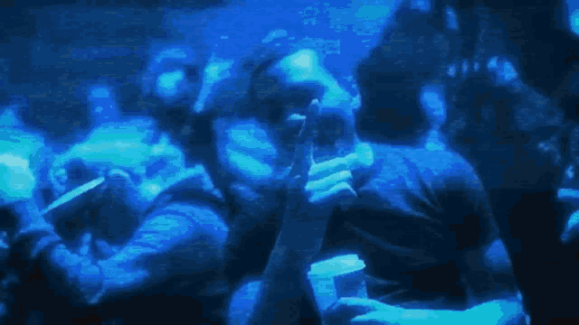 a man is holding a cup in his hand in a crowd