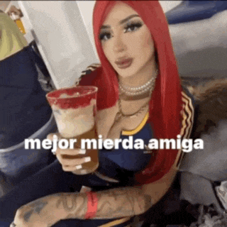 a woman with red hair is holding a drink that says mejor mierda amiga on it