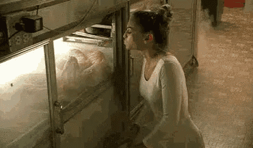 a woman is smelling a turkey in a display case .