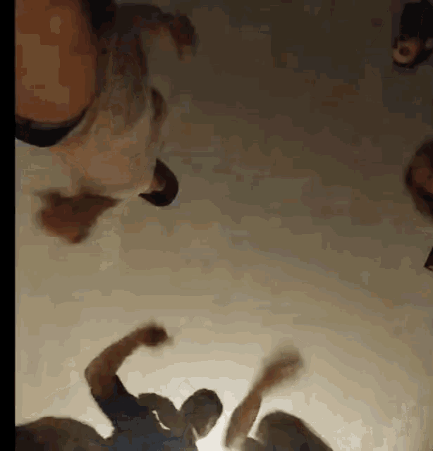 a group of people are dancing in a dark room and looking up at the sky .