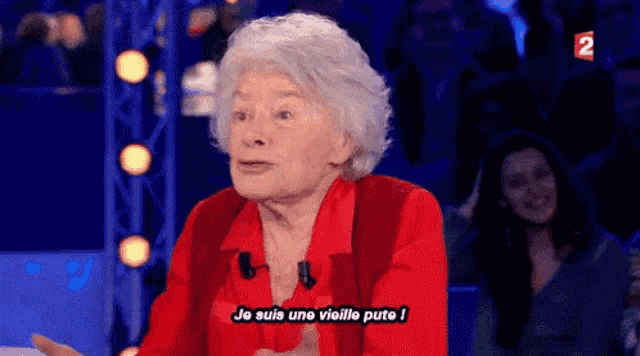 an older woman in a red shirt says je suis une vieille pute !