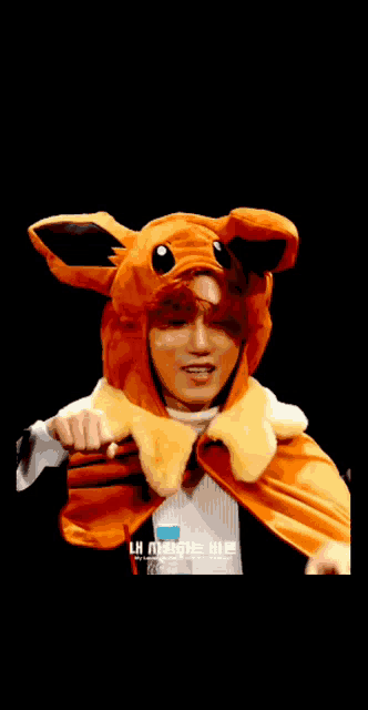a person is wearing a stuffed animal hat and waving their hand