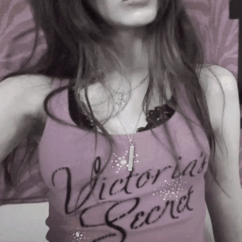 a woman wearing a purple tank top that says victoria 's secret