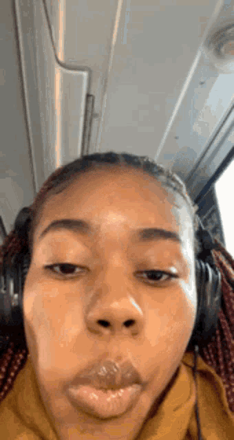 a woman wearing headphones making a funny face with her mouth open