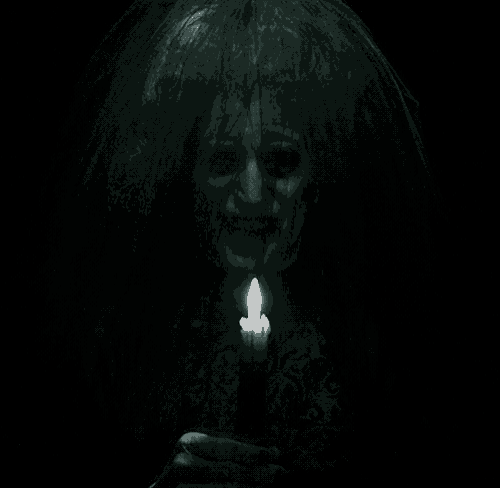 a woman with a veil on her head holds a lit candle