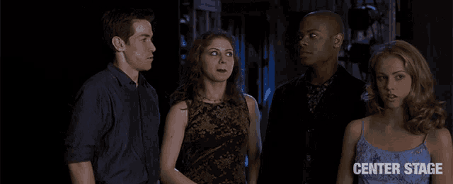 a group of people are standing in a dark room with the words center stage on the bottom