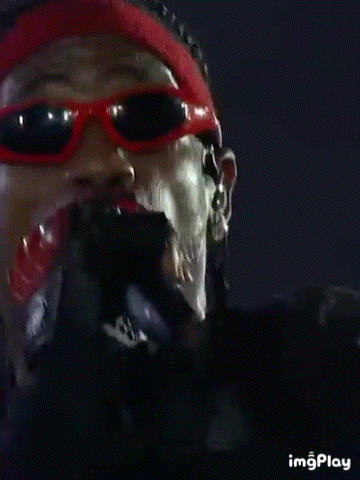 a close up of a man wearing red sunglasses and a headband .
