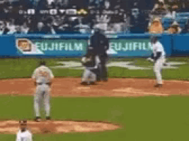 a baseball game is being played in front of an advertisement for fuji film