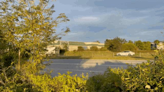 a white car is parked on the side of the road in front of a large building