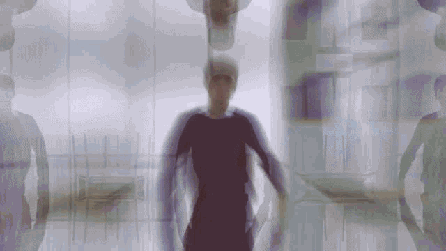 a blurred image of a person standing in front of a glass wall