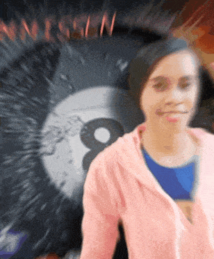 a woman in a pink hoodie stands in front of a sign that says 8