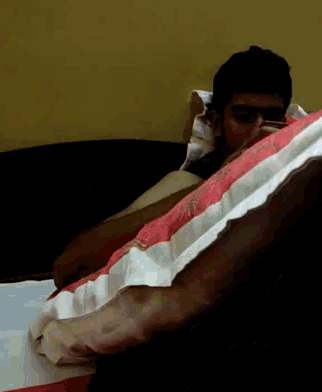 a man is laying on a bed with a striped blanket