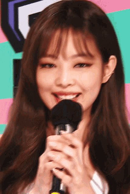 a woman is holding a microphone and smiling