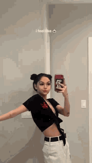 a woman is taking a selfie in front of a mirror with her phone .