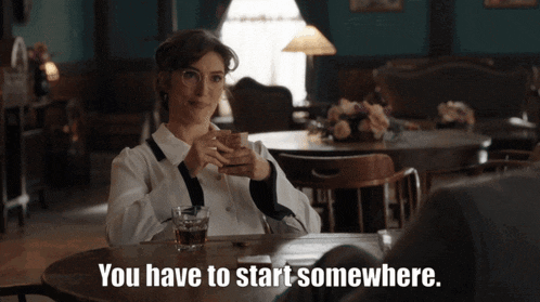 a woman sitting at a table with the words you have to start somewhere on the bottom
