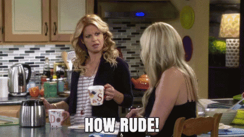 two women are sitting at a table in a kitchen and one of them is saying how rude