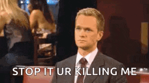 a man in a suit and tie is saying `` stop it ur killing me '' while sitting in a bar .