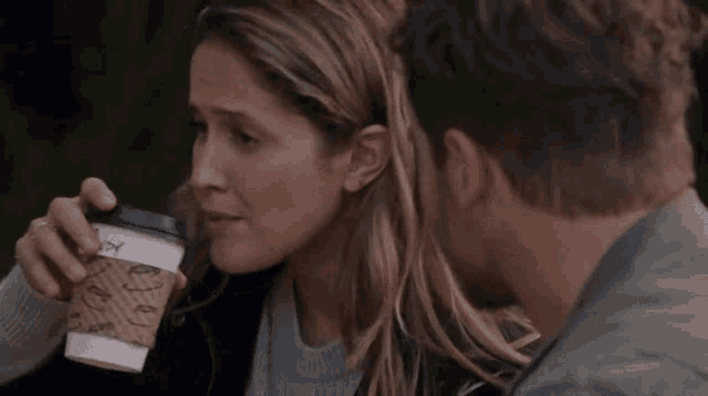 a woman drinking from a coffee cup that says happy on it