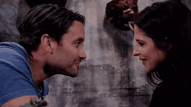 a man and a woman are looking into each other 's eyes and smiling