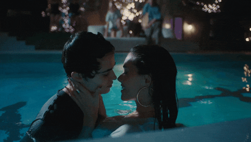 a man and a woman kissing in a swimming pool