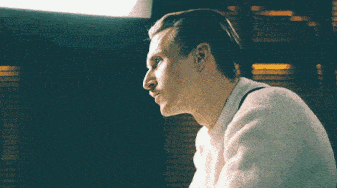 a man wearing a white sweater looks to his left