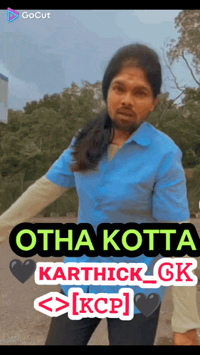 a man in a blue shirt is standing in front of a sign that says otha kotta karthick gk kcp