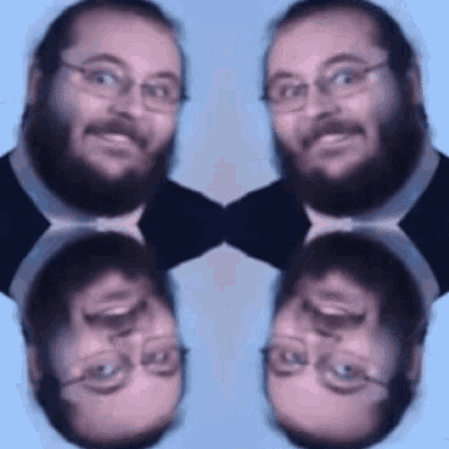 a man with a beard and glasses is standing in front of a mirror .