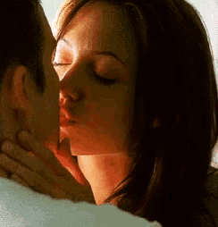 a man and a woman are kissing with their eyes closed