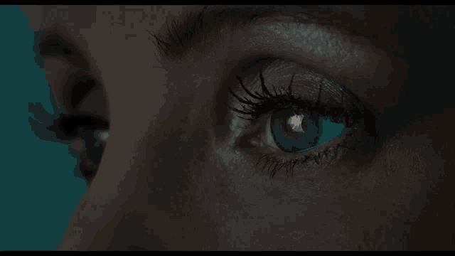 a close up of a woman 's eye with blue eyes