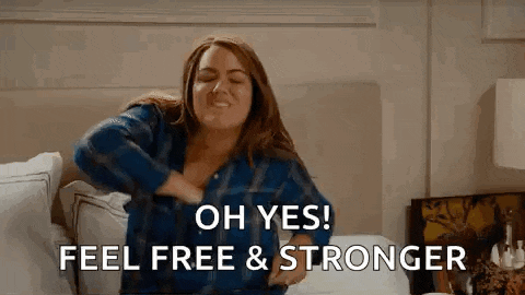 a woman is sitting on a bed with her hands on her chest and saying `` oh yes ! feel free & stronger '' .