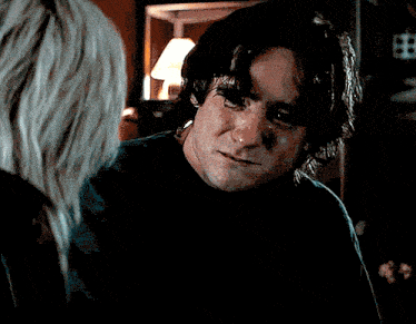 a man in a black shirt is looking at a woman