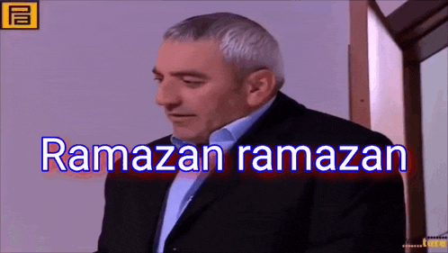 a man in a suit stands in front of a window and says ramazan ramazan