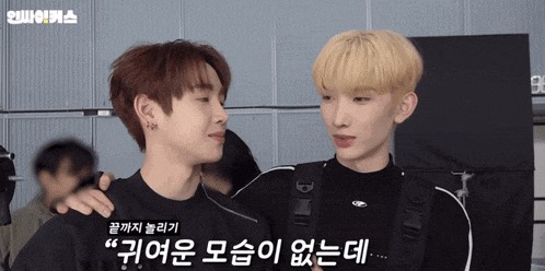 two young men are standing next to each other and one of them is wearing a black shirt that says dior