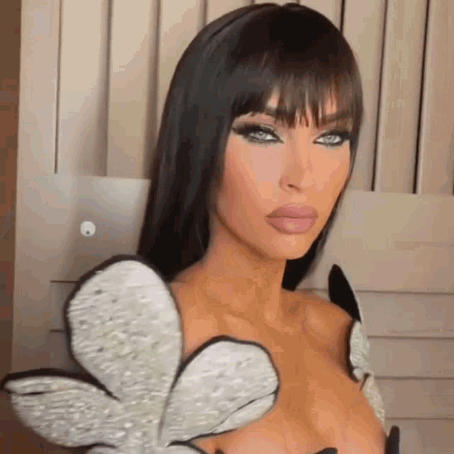 a close up of a woman 's face with a fringe and a very plunging neckline .