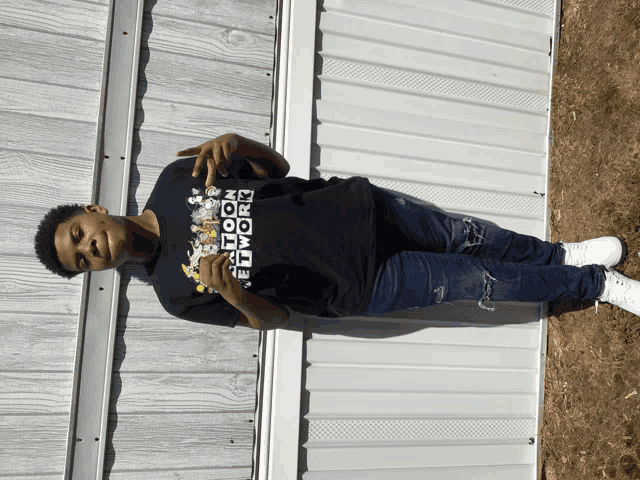 a young man wearing a black cartoon network shirt