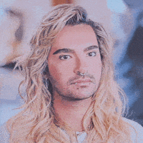 a man with long blonde hair has a nose ring in his nose