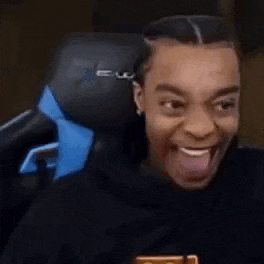 a man is sitting in a chair with his tongue out .