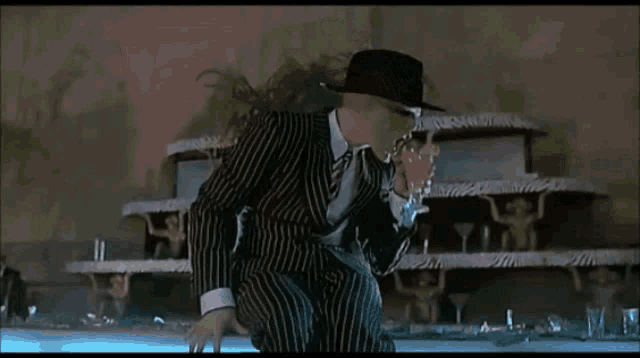 a man in a striped suit is standing in front of a cake