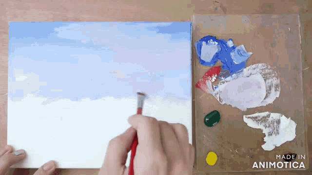 a person is painting on a canvas with the words made in animotica behind them