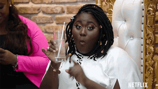 a woman is holding a glass with a straw and the word netflix is visible on the bottom