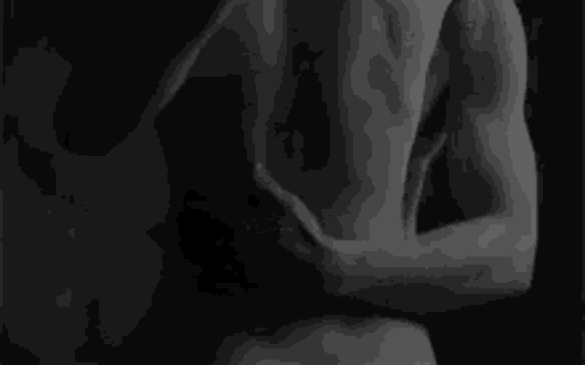 it is a black and white photo of a man and woman hugging each other .