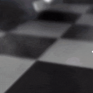 a spotlight is shining on a black and white checkered floor in front of a poster